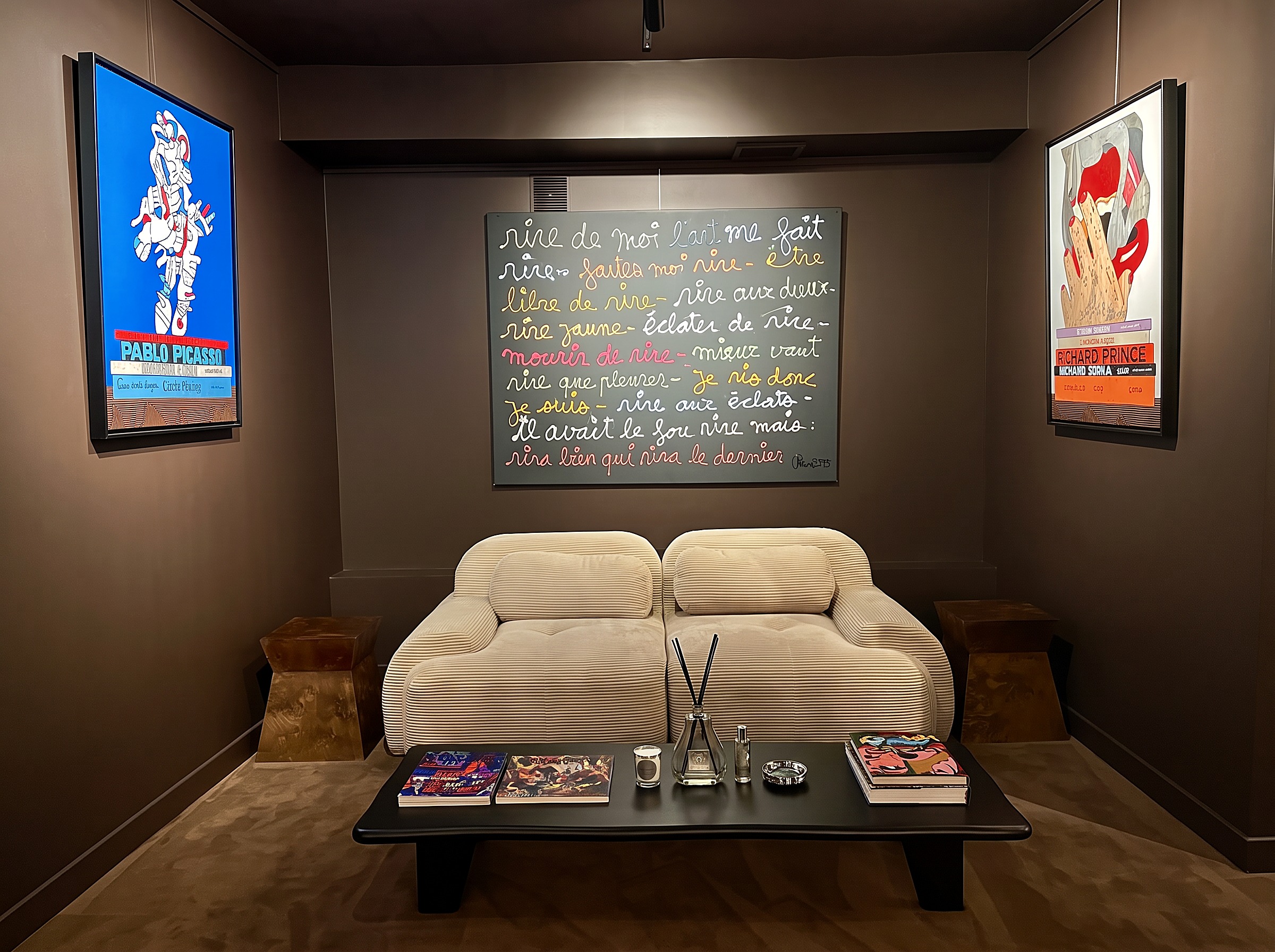 The lower lounge with its cream corduroy sofa and artworks, with artworks