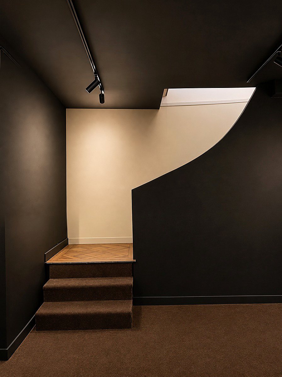 The stairs leading down to the lower level, without artworks